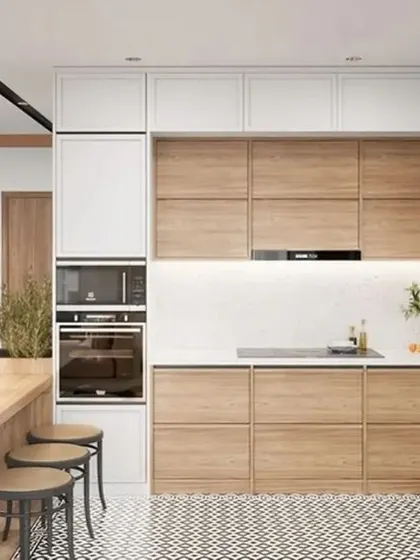 This L-shaped kitchen combines light wood cabinets with white uppers and a patterned floor. The attached dining table makes it a perfect family-friendly, open-concept space.
