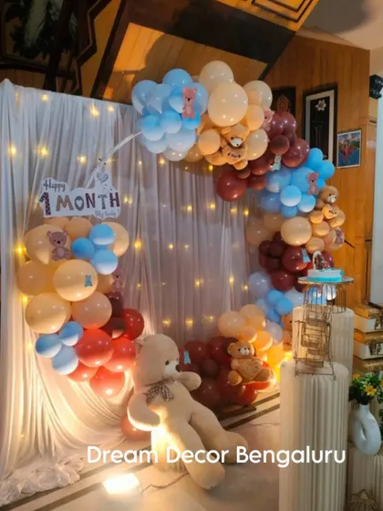 A cozy and cute setup for a one-month celebration. The teddy bear theme with a circular balloon arch and fairy lights is perfect for marking this special first milestone.