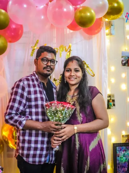 A happy couple posing in front of our birthday decorations. The balloon arch and fairy light backdrop create the perfect spot for memorable photos.