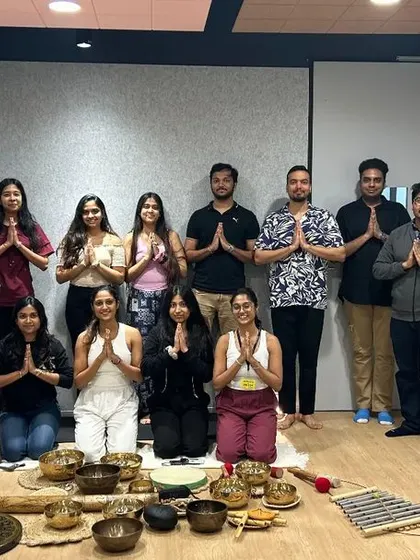 A group photo with participants after a corporate sound healing session, all sharing a sense of calm and gratitude.