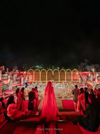 The bride makes her grand entrance down the iconic steps of the venue, walking towards her partner in a truly breathtaking moment.