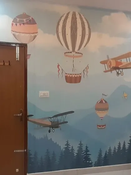 A whimsical adventure-themed wallpaper with hot air balloons and airplanes over a forest landscape, perfect for a child's room.