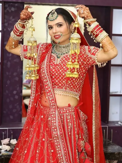 A joyful bride holding her kalire. This full bridal look, from the HD makeup to the placement of the bindi and jewelry, is what you will learn to create in my comprehensive bridal course.