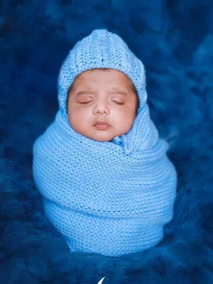 A collage showing two brothers, with the younger one dressed in a blue wrap to match his older brother's first newborn photo. A sweet family tradition!