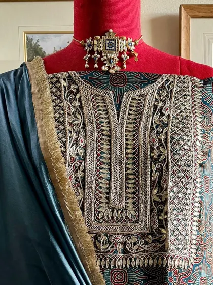 We present a handcrafted modal silk kurta featuring a yoke heavily embroidered with Gota Patti and Marodi work. It is paired with a solid Italian silk organza dupatta with complementary embroidery.