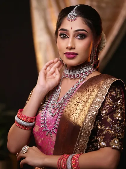 A sophisticated bridal look perfect for a reception, featuring a pink and brown saree with modern diamond jewellery. The makeup is focused on a sharp eye look and a bold lip.