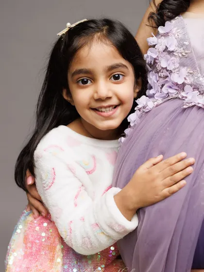 A close-up of a big sister in training, full of love and curiosity for the new baby. These are the moments that show a family's love expanding.