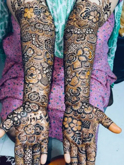 Bridal mehndi for Feroz's bride, with his name hidden among the flowers on her palm. The design is rich and traditional.