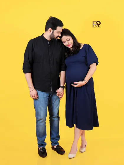 A bright and joyful couple's portrait. The simple outfits and the vibrant yellow backdrop create a modern, happy, and energetic feel.
