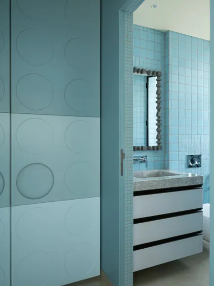 This bathroom for one of the sons features a playful yet minimalist design. Soft blue hues and circular motifs on the cabinetry create a sense of rhythm and fun.