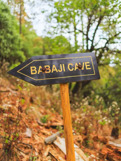 A sign pointing the way to Babaji's cave. The journey to these sacred places is as much a part of the experience as the destination itself, a pilgrimage of body and soul.