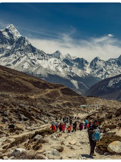 A team of trekkers making their way along the classic EBC trail. The path winds through the Khumbu valley, with the majestic peak of Ama Dablam and other Himalayan giants watching over the journey.