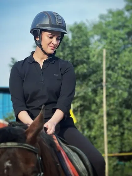 A rider enjoys a quiet moment on horseback, reflecting on her lesson. The connection with the horse is a rewarding part of the learning process.