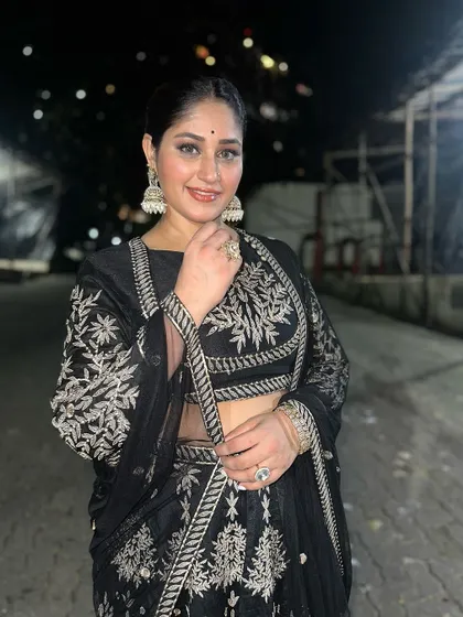 Donam Bajwa smiles in her Dhanteras outfit, a black lehenga with silver floral embroidery, proving that renting is perfect for festive occasions.