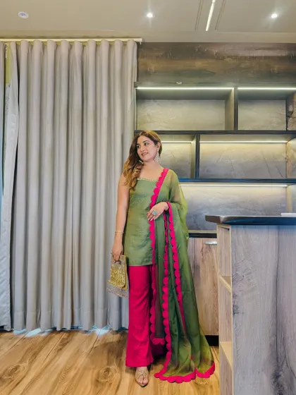 This olive green and fuchsia suit is a perfect example of custom styling. The bold fuchsia scallop detail on the organza dupatta makes the entire outfit stand out without screaming for attention.