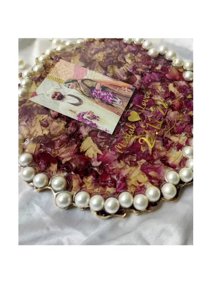 A close-up of a finished varmala preservation frame, showcasing the deep red petals, the couple's photo, and the elegant pearl border. Every detail is crafted to make your memories shine.