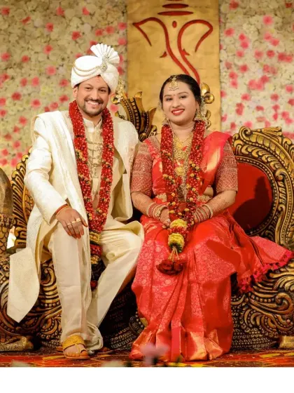 A regal portrait of the couple seated on ornate peacock-themed thrones, a classic shot from their grand wedding reception.