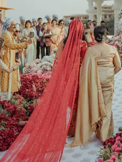 The bride's breathtaking walk down the aisle, with a long, beautiful veil and the groom waiting expectantly.