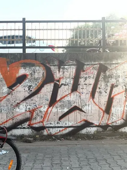 A shot of the UP graffiti piece with a cyclist passing by, capturing the art in its public street context.