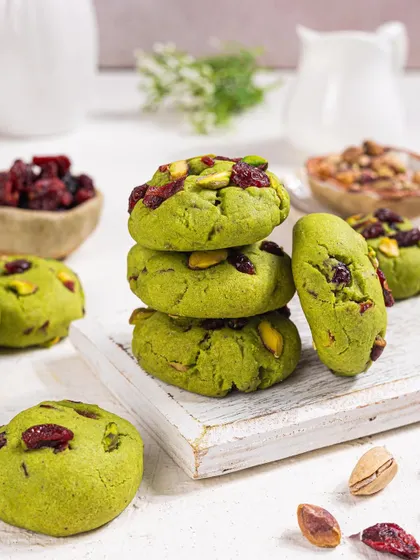 A stack of vibrant pistachio and cranberry cookies, shot in a bright, high-key style to make the colors pop.
