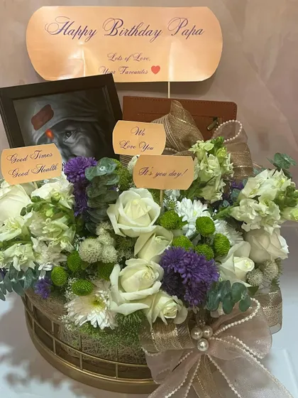 A heartfelt, last-minute birthday delivery for a beloved Papa. This hamper is deeply personal, featuring a framed picture, custom messages, and a serene arrangement of white roses and purple statice.