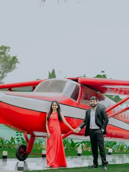 A classic couple's portrait in front of the red airplane, a standout feature of our venue.