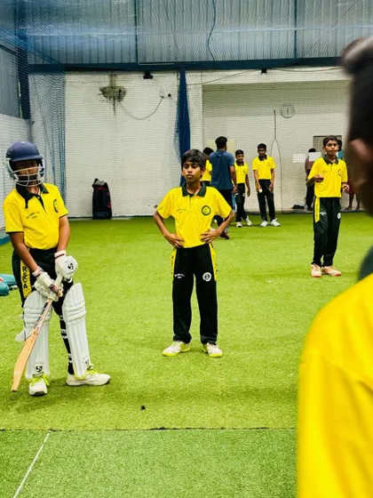 A young batter stands ready in the indoor nets, a space where fundamentals are built and confidence is grown, regardless of the weather outside.