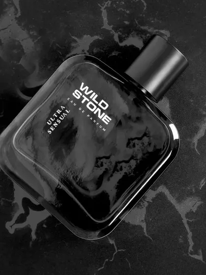 A sleek, monochrome shot of Wild Stone perfume on a black marble surface. This minimalist and high-contrast style communicates sophistication and is ideal for luxury men's grooming products.