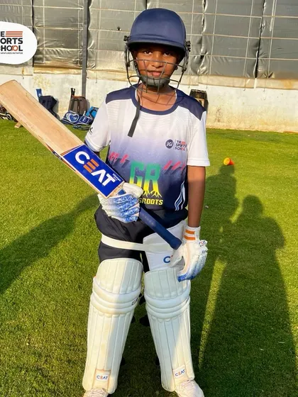 A young cricketer in full gear, ready for the summer camp, where new dreams and skills are forged.