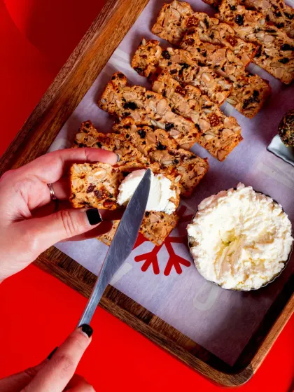 Spreading creamy Fromage Blanc on a crisp. This simple action shows how easy and interactive my party platters can be for your guests.