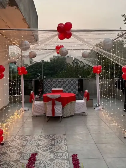 Another view of the romantic terrace dining setup, showing the rose petal path leading to the beautifully decorated table for two.