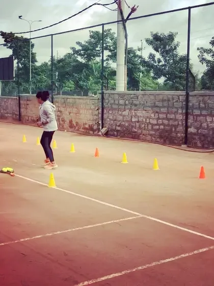 A player works on her footwork patterns around cones, a key drill for improving court coverage.