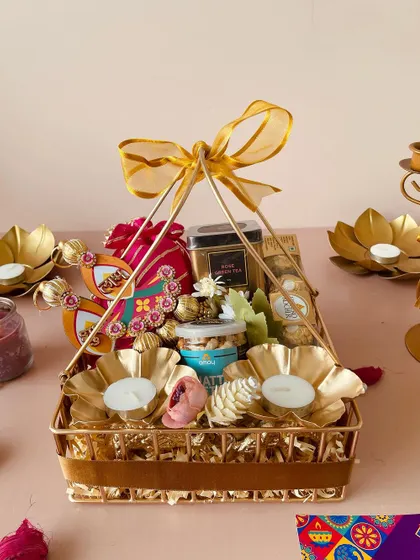This front-on view shows the beautiful arrangement of festive items within the golden metal basket, ready to impress any recipient.
