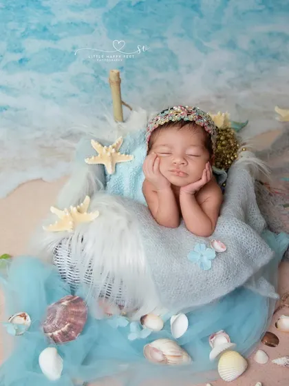 This sweet baby is in the perfect froggy pose, dreaming of the ocean. The combination of a classic newborn pose with a creative beach theme works beautifully.