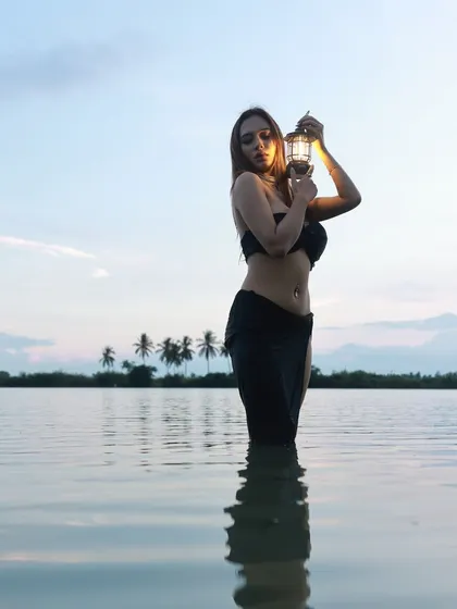 An artistic and sensuous concept shoot at a lakeside. The combination of the water, the fading light, and the single lantern creates a powerful, moody visual that stands out.