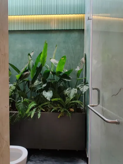A skylit shower area in a penthouse apartment, with a planter bringing a touch of tropical greenery into the bathroom.