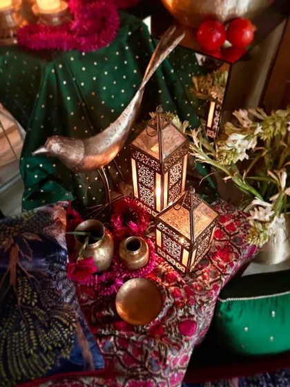A close-up of the mood board, showing the detail of a brass bird, lanterns, and polka-dotted green fabric.