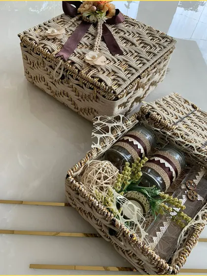 Our jute hampers are available in a variety of colors, including this neutral beige. The box is filled with beautifully packaged jars and decorated with natural elements.