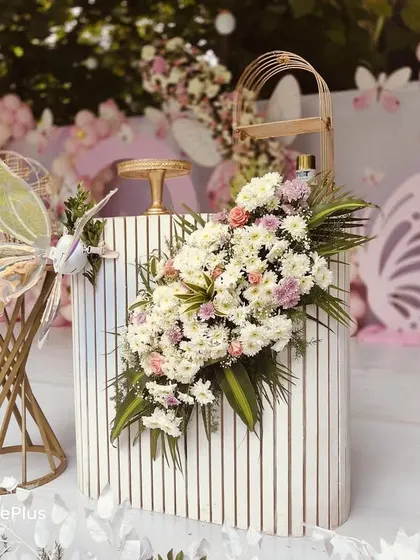 Details make the design. This fluted table, a very trendy item, is decorated with a lush floral arrangement and paired with butterfly-themed props for a sophisticated touch.