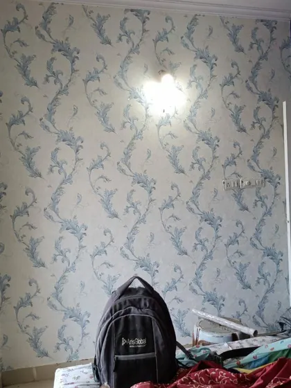A bedroom installation of a blue and white wallpaper with a classic vine pattern, showing a messy site during work, which I always clean up completely.