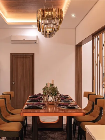 Here is a look at the dining area transformation, featuring a gold-finished partition and individually curved padded chairs. The design creates a glamorous yet comfortable space for the family to enjoy meals together.