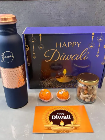 This shows the complete Diwali gift set with the personalized copper bottle. The festive box, greeting card, and traditional treats make it a comprehensive and thoughtful present.