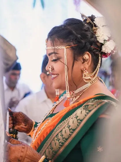 A beautiful candid shot of the bride during her ceremony. The focus is on her happy expression and the traditional details of her look.