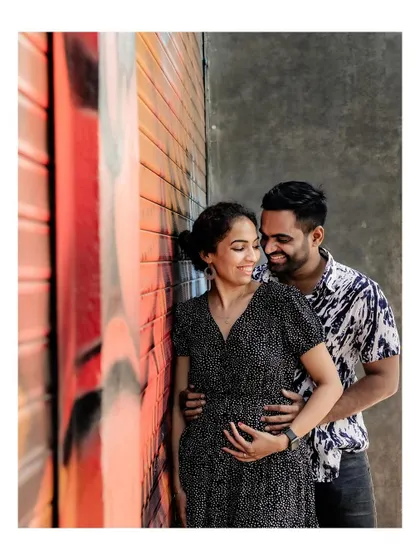 A sweet moment with the couple posing against a colorful graffiti wall.
