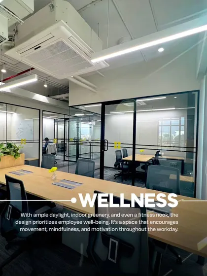 An open-plan desk area at VentureX designed with wellness in mind. The space features ample daylight, integrated greenery in the desk dividers, and ergonomic seating to promote employee well-being throughout the workday.