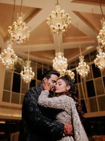 An intimate moment between the couple, framed by the stunning chandeliers of the hotel lobby. Even outside the main event area, we create opportunities for beautiful memories.