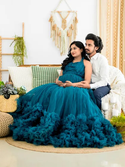 A serene moment for the parents-to-be in our boho-chic studio setup. The mom-to-be is wearing one of our popular ruffled tulle gowns, creating a soft and romantic feel.