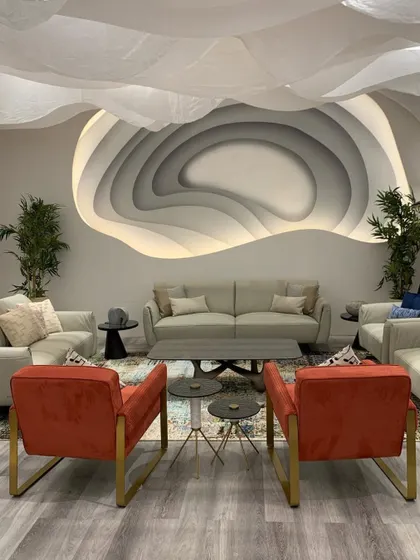The innovative iLounge designed for the IDAC Expo, showcasing parametric design principles. A sculptural wall feature with integrated lighting serves as the focal point, while the fluid fabric ceiling creates an immersive and illusory spatial experience.