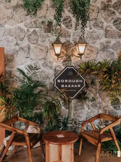 The entrance to our 'Borough Bazaar' event, designed to feel like a European farmer's market. A vintage-style street lamp, rustic wooden furniture, and lush greenery create a charming and welcoming atmosphere.