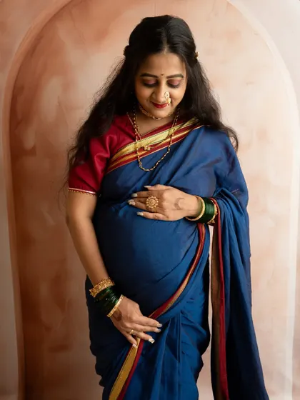 A close-up portrait focusing on the mother's serene expression and the beautiful details of her traditional attire and jewelry.